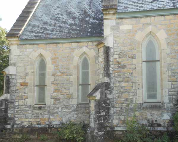 Exterior of building - yellowed plastic-looking material coats the stained glass windows so their design is barely visible