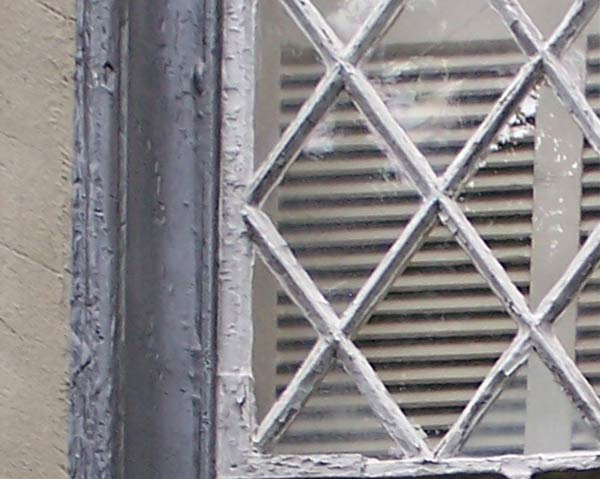 Before image of wood-framed window with peeling paint